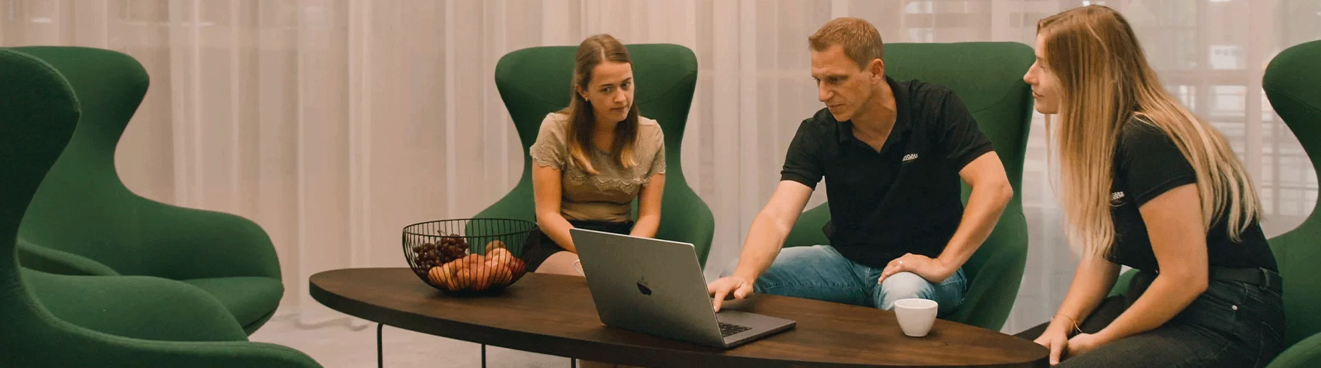 Drei Personen in Besprechung, Grüne Sessel, Laptop