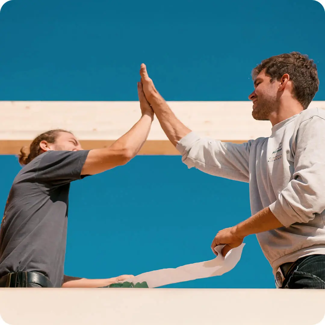 High Five, Zwei Personen auf Dachkonstruktion, Balken aus Holz